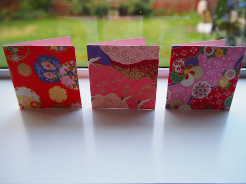 Origami paper gift tags on pink cardstock