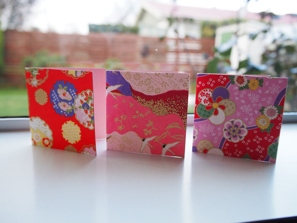 Origami paper gift tags on pink cardstock