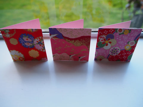 Origami paper gift tags on pink cardstock