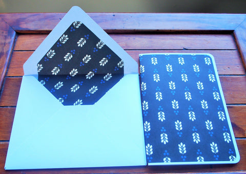 Minimalist leaf design on black paper card and envelope set