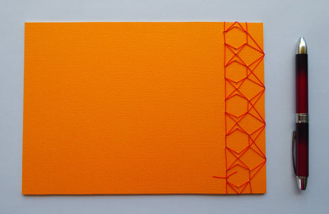 Festive special: notebooks with unique hand-bound decorative designs in rich yellow with kissing fish binding